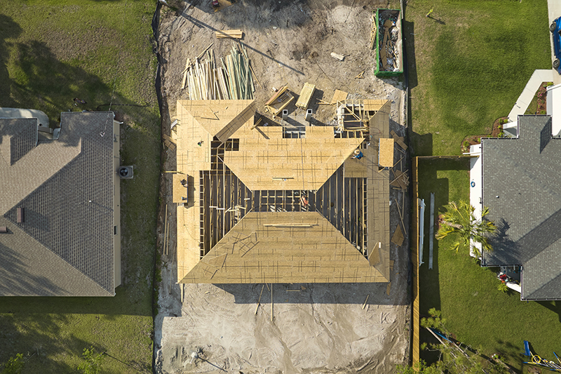 Aerial view of suburban private house wit wooden roof frame under construction in Florida quiet rural area